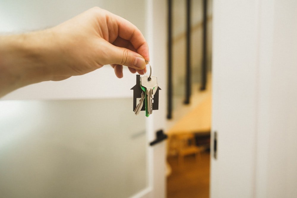 Persona sosteniendo la llave de la puerta de una vivienda